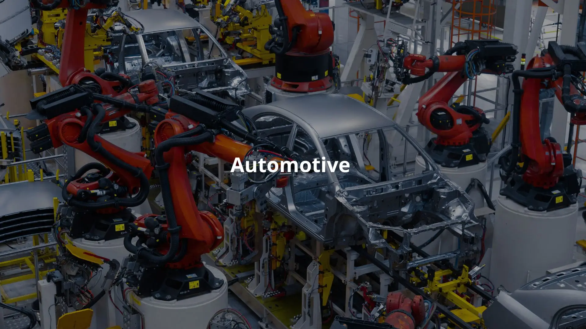 Robotic arms work on car frames in a modern automotive assembly line.